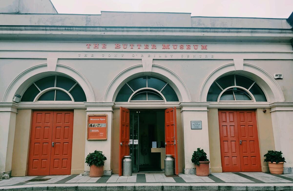 The Cork Butter Museum in Shandon, with red doors and a cream arched fa&ccedil;ade facing the street.